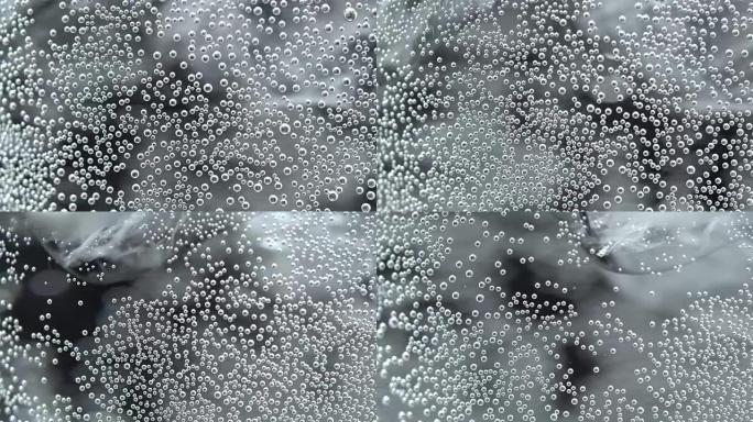 Bubbles on glass with sparkling water in rotation