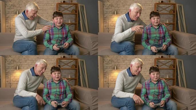 爷爷在游戏机游戏中享受孙子的胜利。老人和一个年轻的胖男孩坐在沙发上。电子游戏。家庭舒适，家庭田园诗，