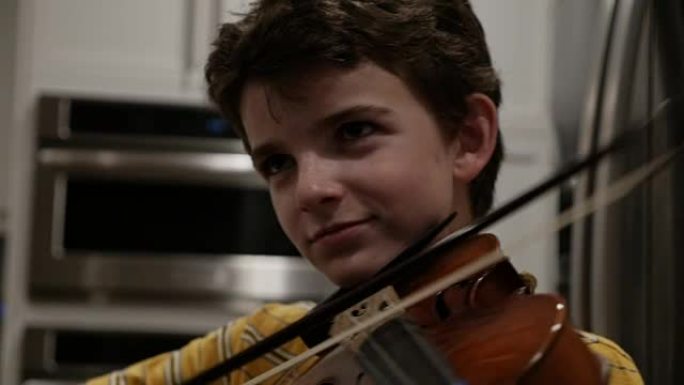 骄傲的小男孩用小提琴唱完一首歌，微笑着