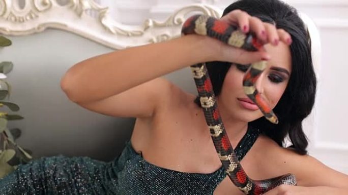 工作室里一个带着蛇的模特女人的肖像。