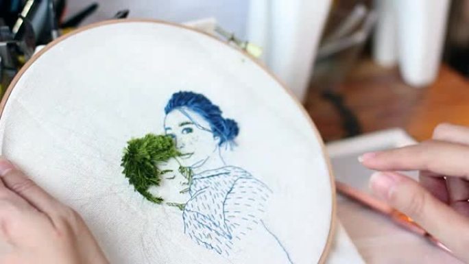 手工缝合针和线，为情侣肖像制作刺绣艺术品。