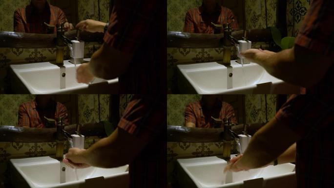 该名男子从分配器中拿出肥皂，然后在水槽中洗手。第1部分