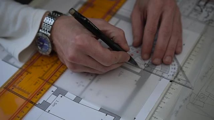 工程师在工作时用铅笔和尺子绘制平面图、图表