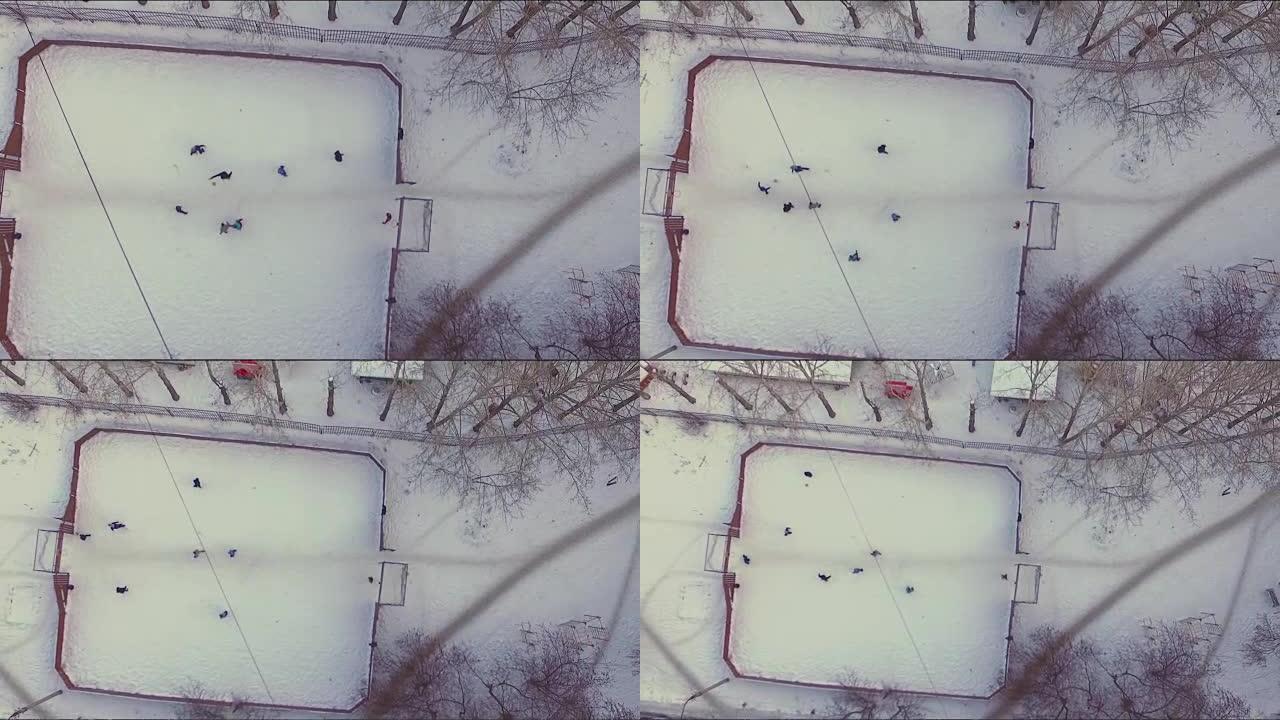 在雪地里踢足球的鸟瞰图。股票。冬天下雪的足球场鸟瞰图。一个小镇，树木，冬天和雪中的运动场。雪地下的冬