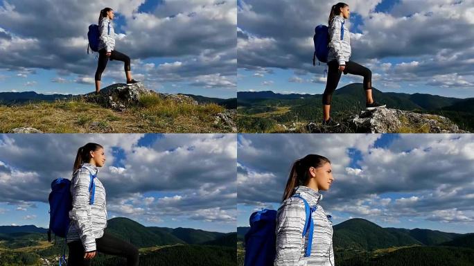 女人背着背包在山顶看日落，徒步女孩庆祝生活，风景优美的自然景观，享受假期旅行冒险
