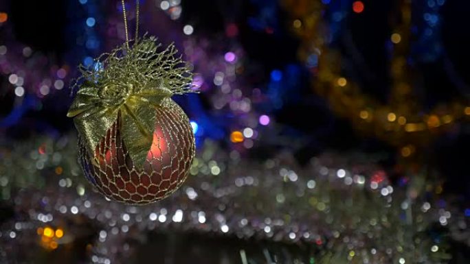 新年和圣诞装饰品。燃烧蜡烛。闪光花环。背景模糊。一个美丽的红球。