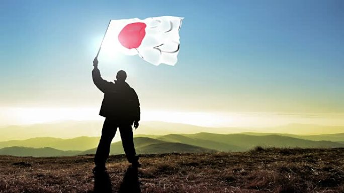 成功的剪影男子获胜者在山顶上挥舞着日本国旗，4k电影院