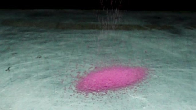 粉红色盐上的水滴慢动作