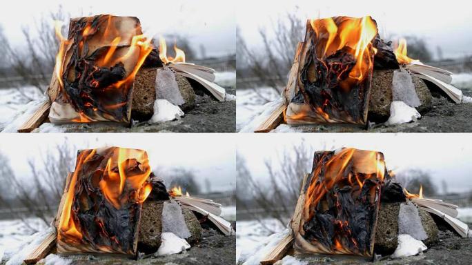 在石头和雪的背景下焚烧书籍
