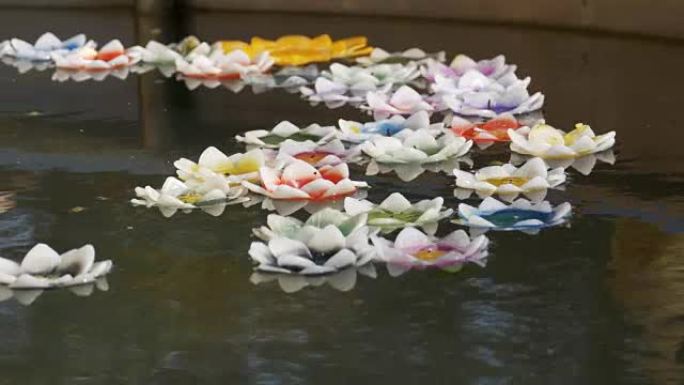 莲花形彩色蜡烛漂浮在佛教寺庙的水上。芭堤雅。泰国