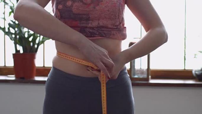 瘦身女人用卷尺测量腰部