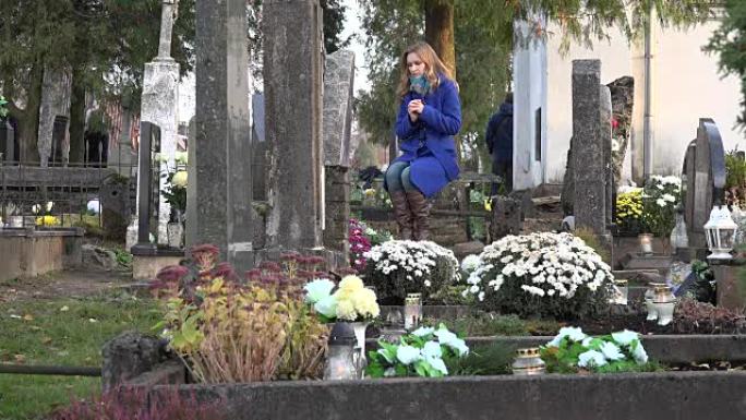 秋天，在墓地的大理石墓碑旁哀悼的妇女。FullHD