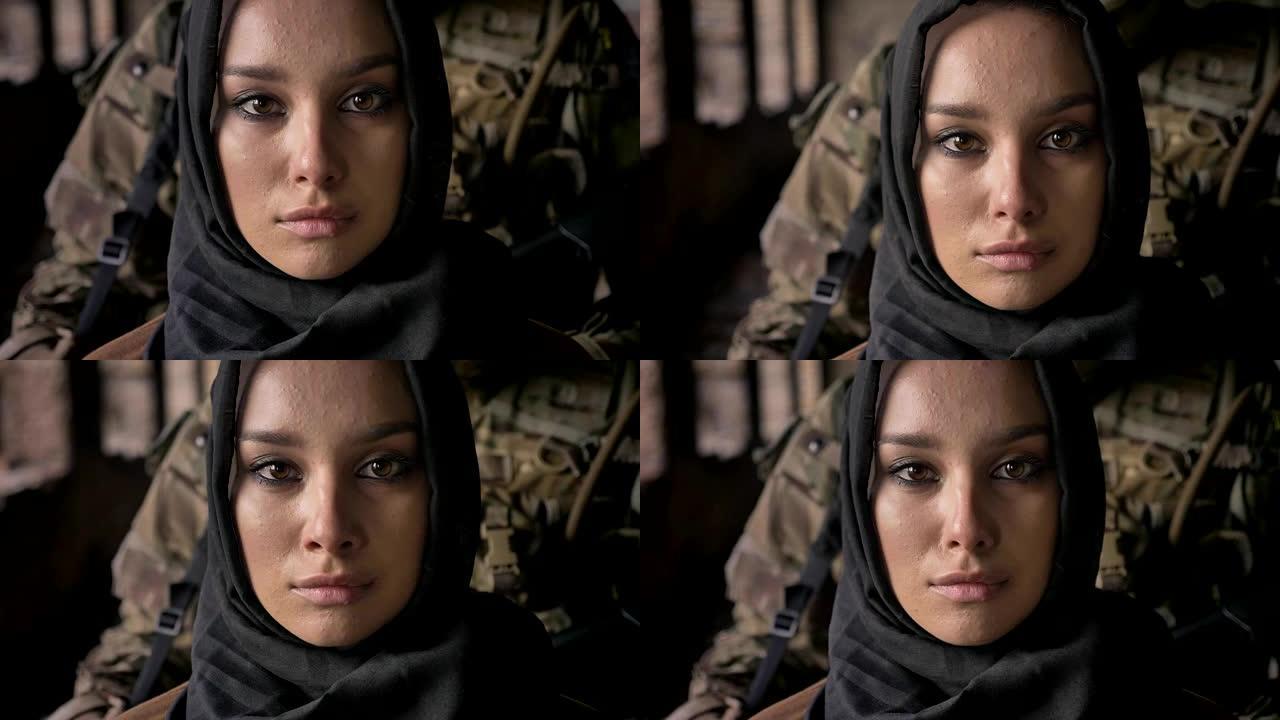 近距离拍摄的年轻穆斯林妇女戴着头巾看着镜头，武装士兵与枪站在妇女身后，军事概念