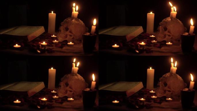 头骨和魔法书周围闪烁的蜡烛火