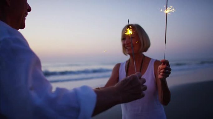 Senior Caucasian couple dancing with sparklers on 