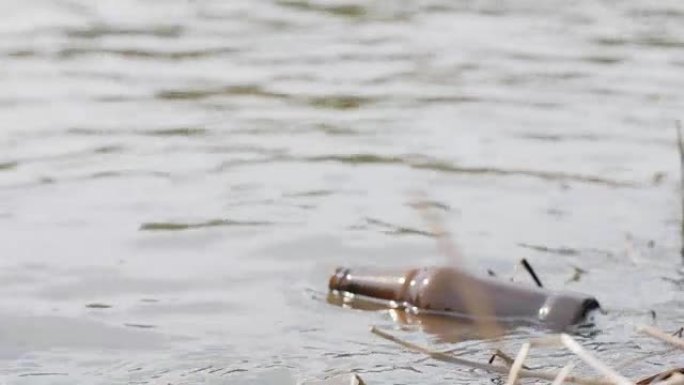 漂浮在河水中的空啤酒瓶。污染水和环境