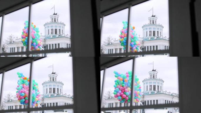 建筑物背景上窗外的一堆彩色气球