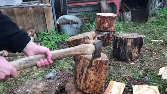 一个人正在砍柴。他将斧头撞到一个木塞上，并用秋千击中了地面上的甲板。