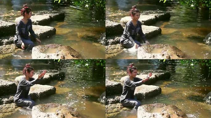 年轻的女孩坐在小溪旁sc起，独自玩水