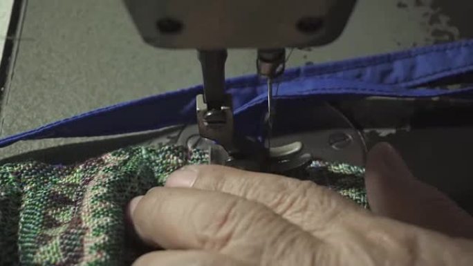 近距离观察，裁缝老太太用缝纫机用泰国面料制作传统包