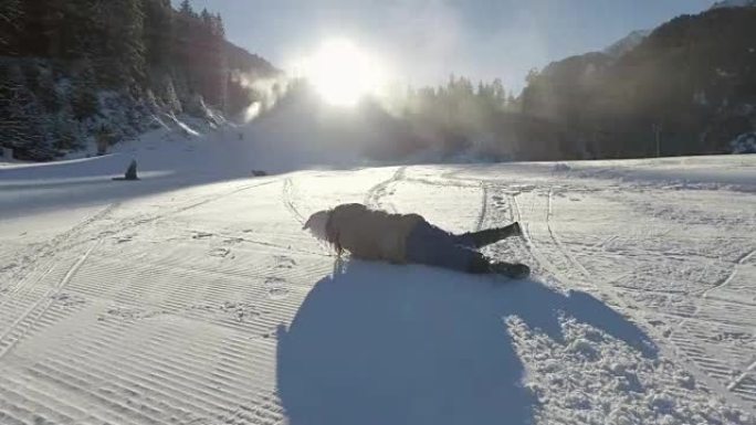 小女孩在雪地里玩耍，滚下滑雪坡