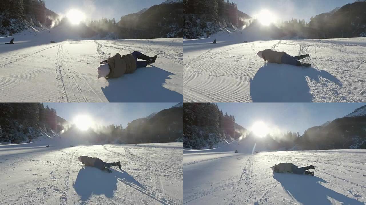 小女孩在雪地里玩耍，滚下滑雪坡
