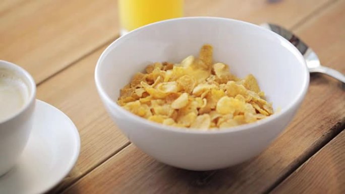 玉米片倒在木桌上的碗中
