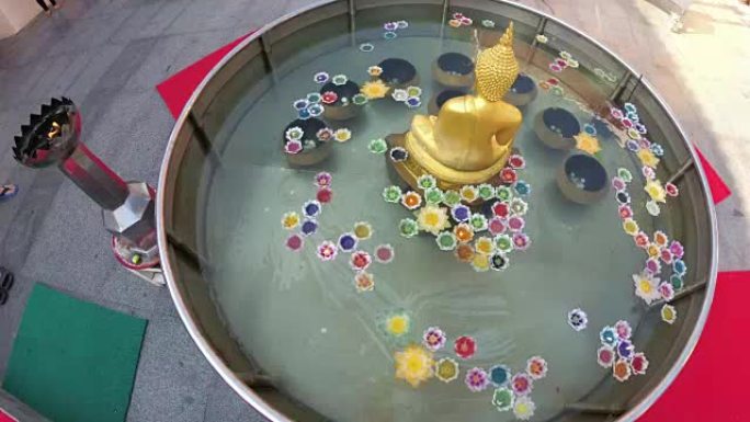莲花形彩色蜡烛漂浮在佛教寺庙的水上。泰国