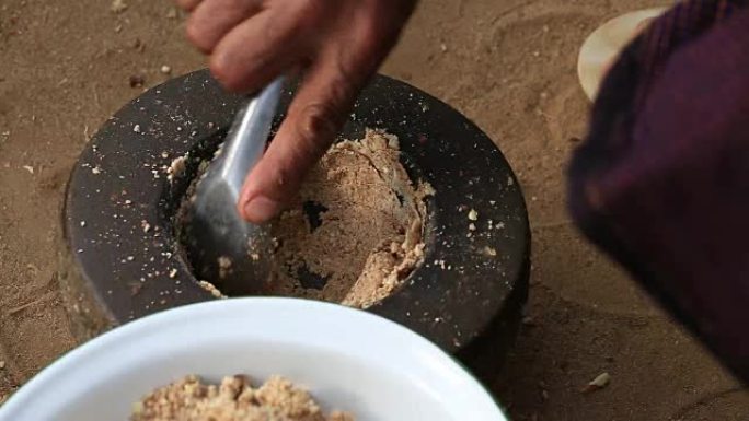坚果在蒲甘院子里的石臼中磨碎。缅甸