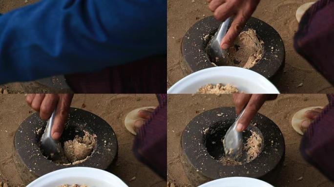 坚果在蒲甘院子里的石臼中磨碎。缅甸