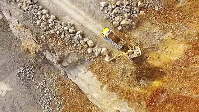 无人驾驶飞机飞越采石场的挖掘机。