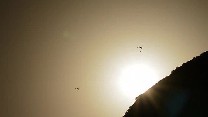 滑翔伞在山上日落时练习滑翔伞，背光