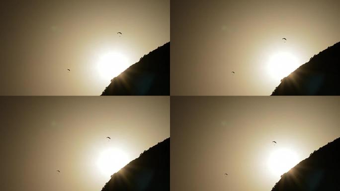 滑翔伞在山上日落时练习滑翔伞，背光