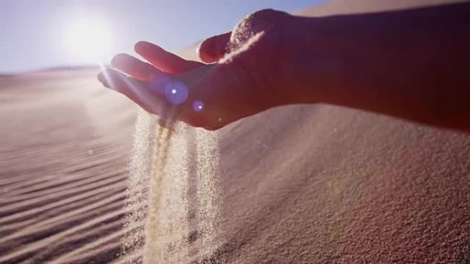 干热的沙漠沙子从女性手中流出