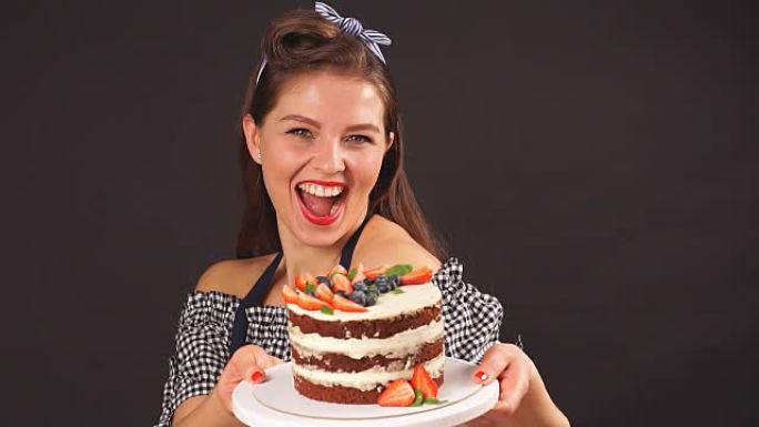 快乐女孩糕点厨师拿着一个装有蛋糕的托盘