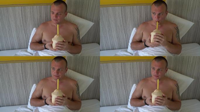 一个男人在床上喝椰奶
