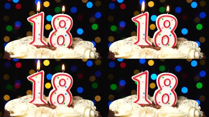 蛋糕上的18号-18岁生日蜡烛燃烧-最后吹灭。彩色模糊背景