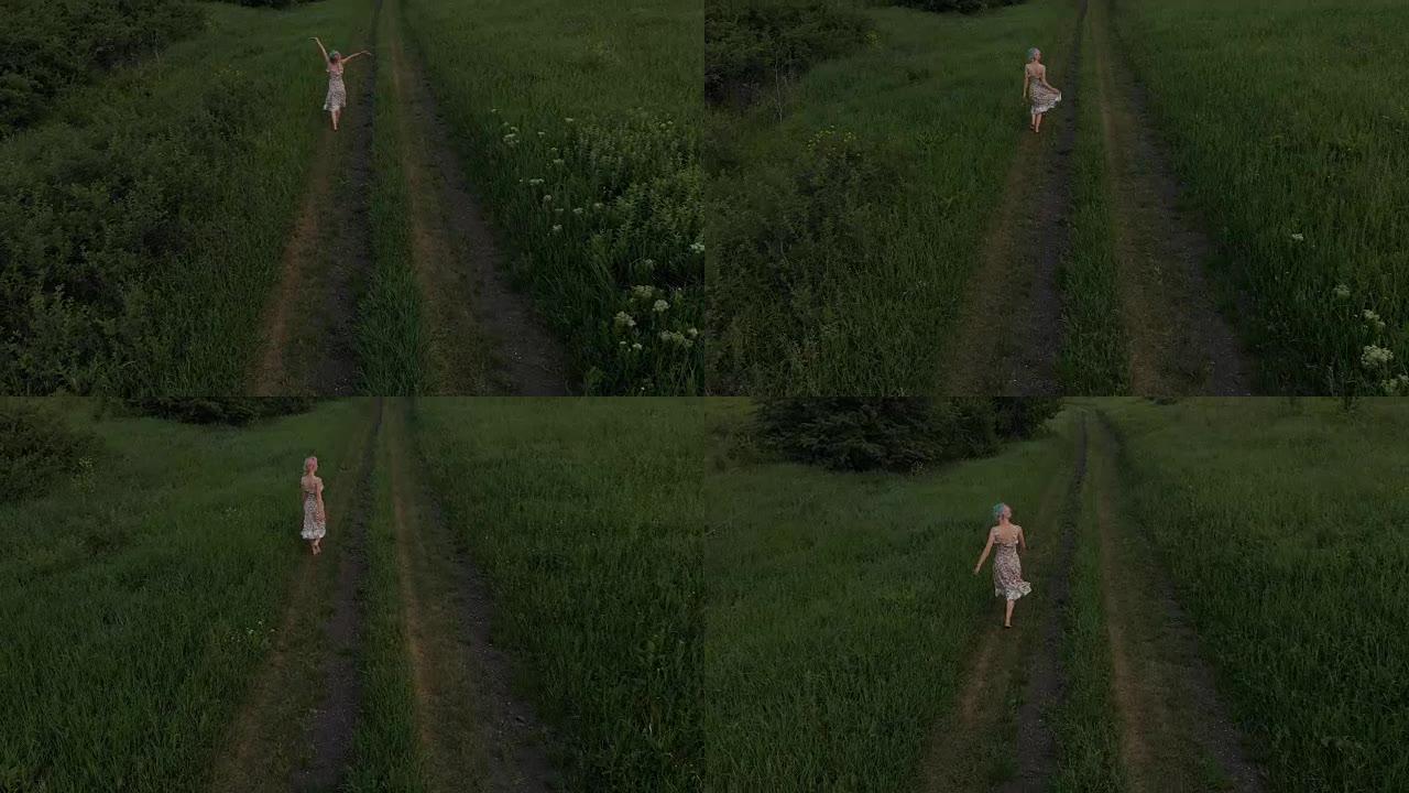 开朗的年轻女孩赤脚走在乡间小路上。鸟瞰图。拍摄于马维克航空4k 100kbps