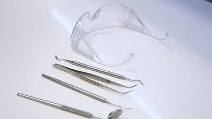 一段牙医的设备放在桌子上的视频，牙医从桌子上拿走了一些他的设备