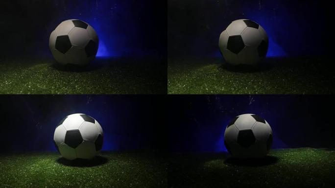 滑块镜头。足球场上的传统足球。在绿色的草地上近距离观察足球 (足球)，背景为深色的雾气。选择性聚焦