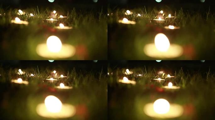 许多小蜡烛在夜晚，在绿草