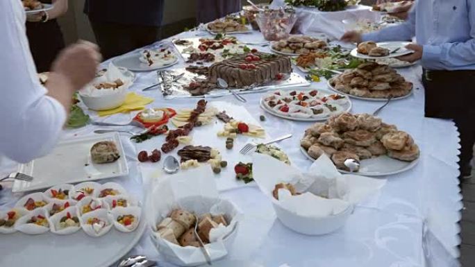 几个人从瑞典餐桌上拿盘子上的食物的镜头