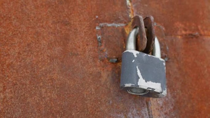 锁在生锈的铁门上。关闭旧门铁旧生锈背景