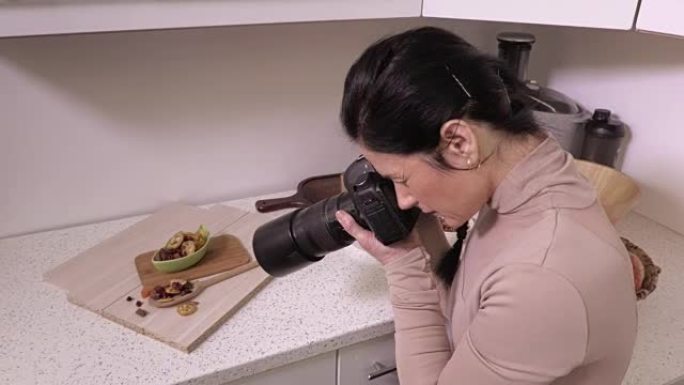 女摄影师在厨房拍摄食物照片