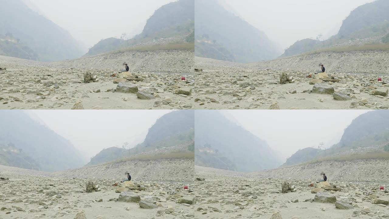 尼泊尔向导在石头上休息。Manaslu电路长途跋涉。