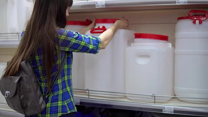 一名年轻女子在超市里选择了一个大水箱。