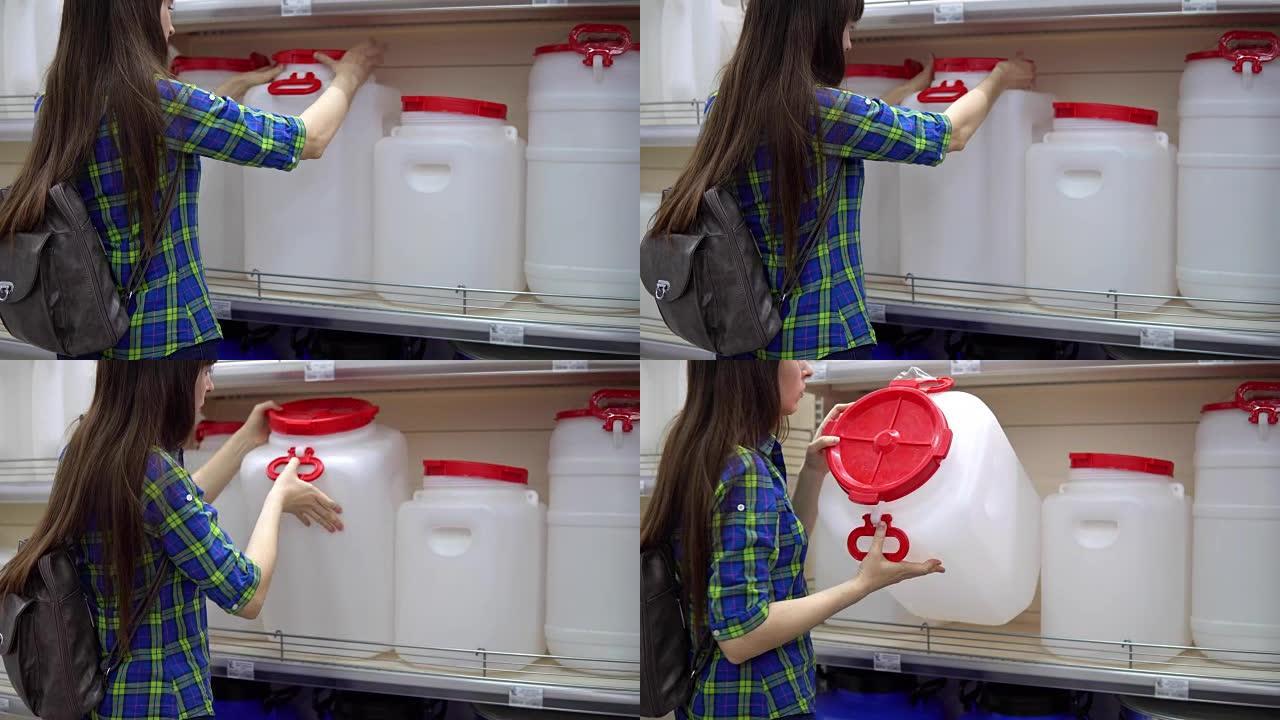 一名年轻女子在超市里选择了一个大水箱。