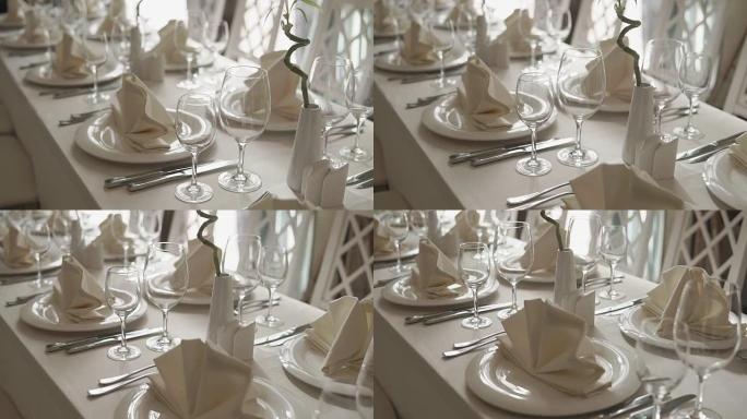 白色陶瓷餐具放在咖啡馆的白色亚麻桌布上