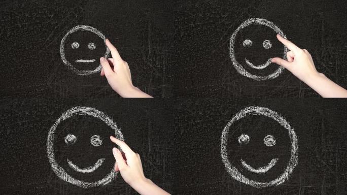在黑板上手绘不快乐的笑脸。女性的手翻阅并选择微笑。