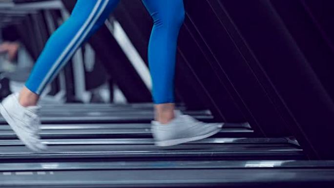 Adult woman runs on treadmill at the fitness centr